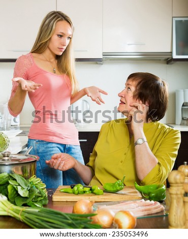 Sad mature female with adult daughter  sharing bad news in kitchen
