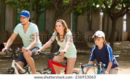 American family riding bicycles in park togetherness on sunny day