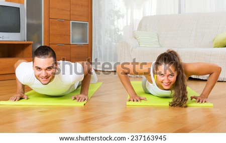 Adult smiling people doing yoga on mats in room