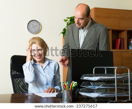Angry boss screaming at careless aged secretary in office