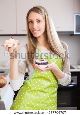 woman in apron with cakes in kitchen