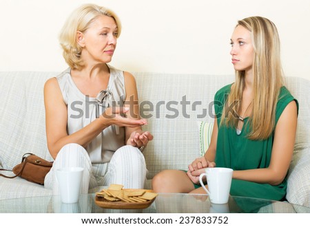 Serious mother and daughter talking in home