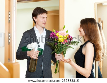 Young man giving gifts to girl at home
