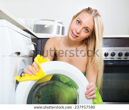 girl cleaning washing machine at home kitchen