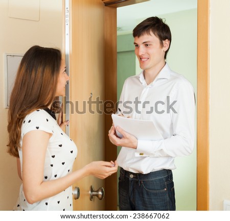 Man conducting  survey among people  with paper in door