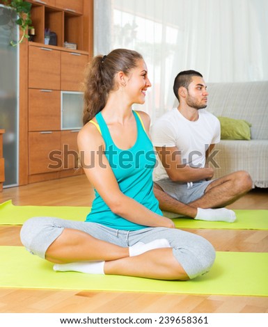 Adult people doing yoga on mats indoor