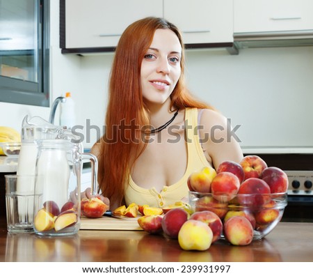 long-haired girl in yellow cooking with peaches at home kitchen