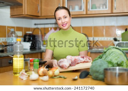 Portrait of happy smiling woman preparing dinner for family indoor