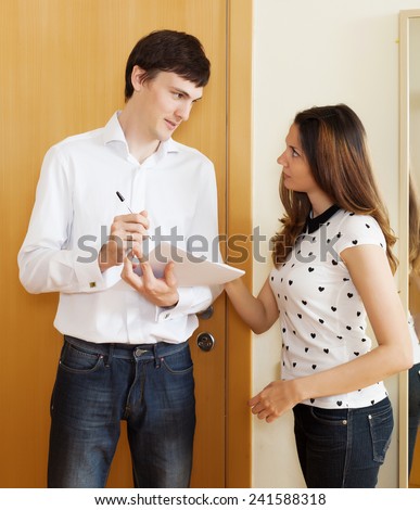 Handsome man conducting  survey among people at door