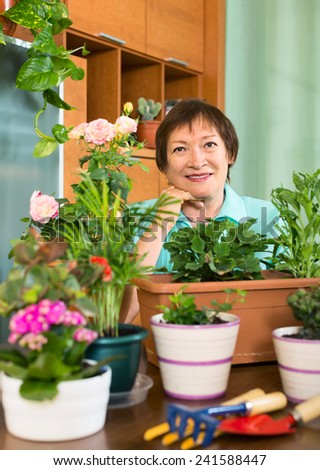 Smiling elderly woman and  her small garden  at home