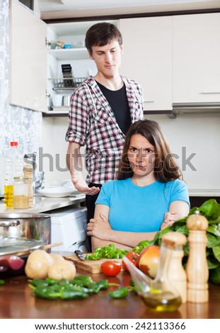 Family quarrel. Sad woman listening to man at home kitchen