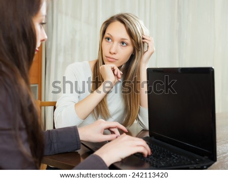 girl talking with employee with notebook at table in interior of home or office