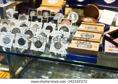 BARCELONA, SPAIN - OCTOBER 28, 2014: Many gold and silver coins on counter at numismatics store