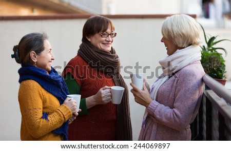 Group of smiling female pensioners drinking tea at balcony