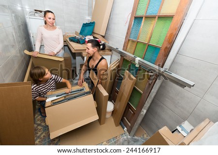 Parents with teenager son packing things before relocation