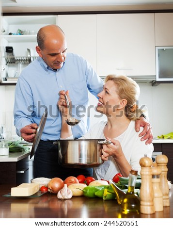 Elderly couple cooking vegetables at home kitchen