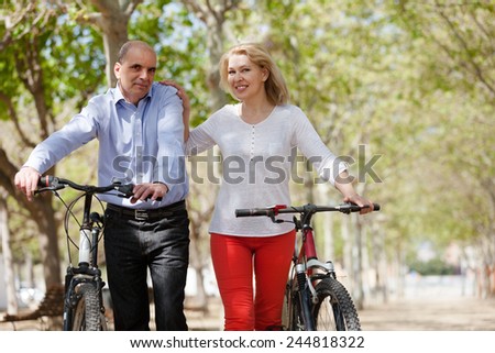 Elderly happy couple walking together in a summer park