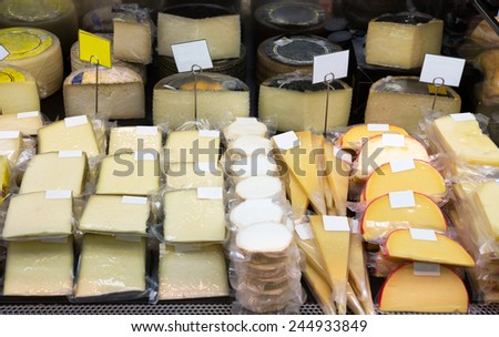 Tasty cheese in packs and in bulk on counter at store