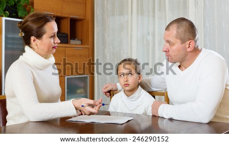 Sad family  with documents at table in home