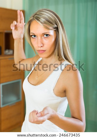 Angry young woman raising hand during quarrel