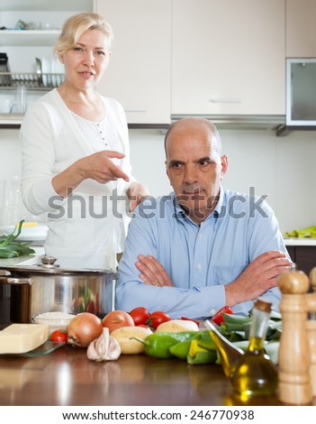 Senior mature couple having disagreement at kitchen