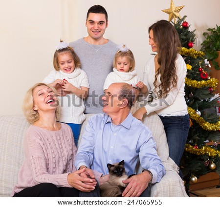 Long european family with grand children decorating New Year tree