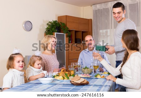 Young man congratulating heartily family member at the table at home