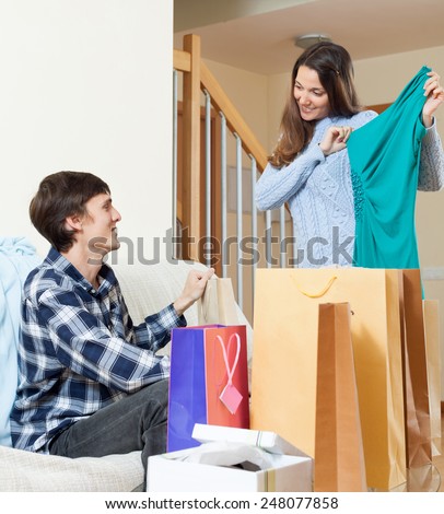 Happy  woman and man with clothing and shopping bags in home
