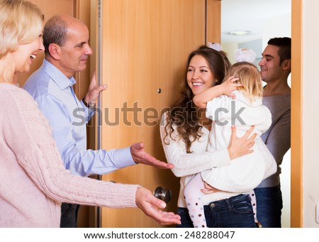 happy young family with two daughters visiting grand parents