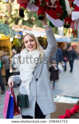 Portrait of female customer near counter with Christmas gifts outside