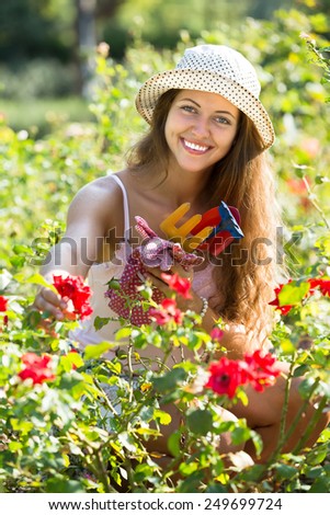 Portrait of smiling casual girl in roses plant at garden