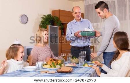 Happy people congratulating heartily family member at home