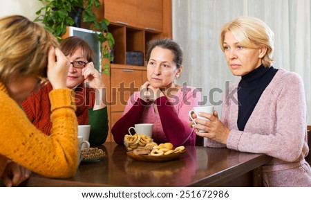 pensioners listening to sad story of their friend at table  indoor