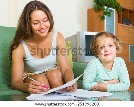 Smiling girl watching her mom dealing with insurance papers
