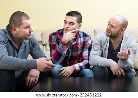 Three guys sitting at the table and sharing the problems