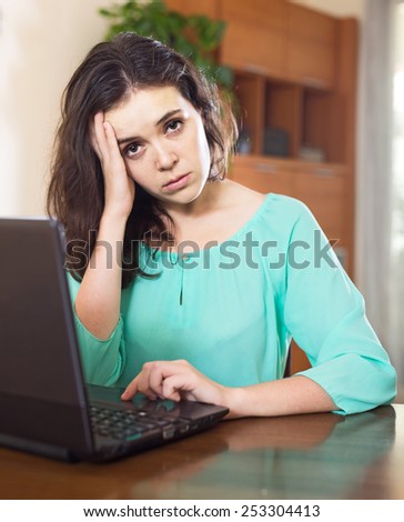 Crying  girl with laptop in living room