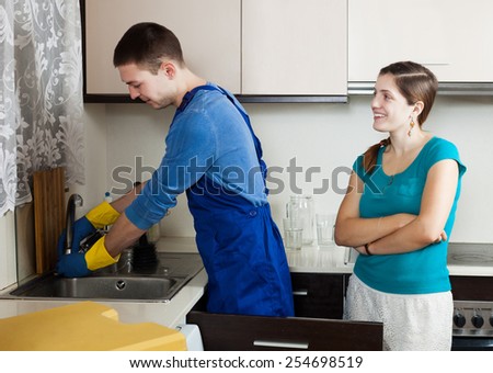 Woman watching as plumber repairing  water lines in home