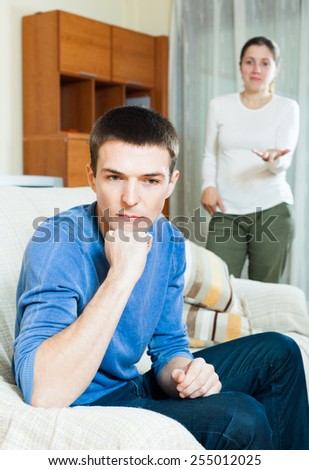 Family quarrel. Unhappy guy with aggressive wife at home