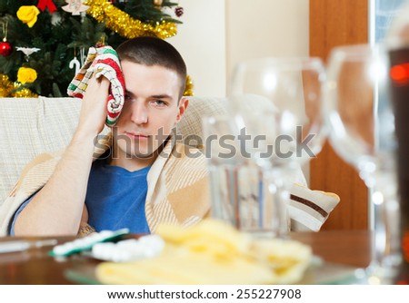 Man having hangover during christmas holidays at home