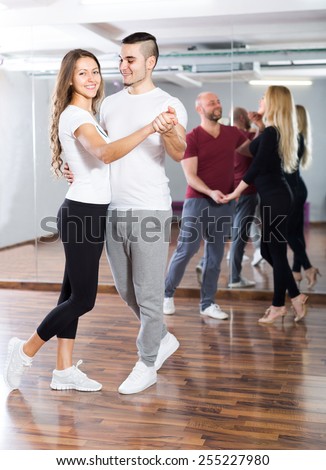 Happy young people having dancing class in  school