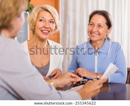 Two positive female pensioners taking legal advice from public notary