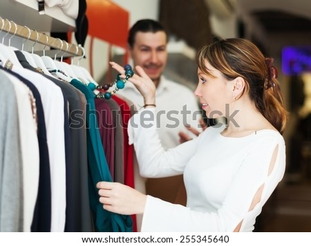 Man and woman choosing clothes at clothing boutique