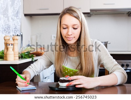 girl weighing cakes on kitchen scales at kitchen