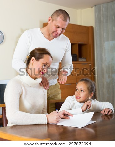 Happy family with documents at the table in the living room