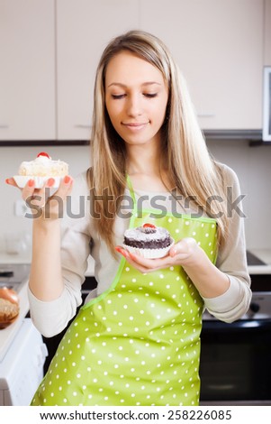 Blonde girl with cakes in kitchen