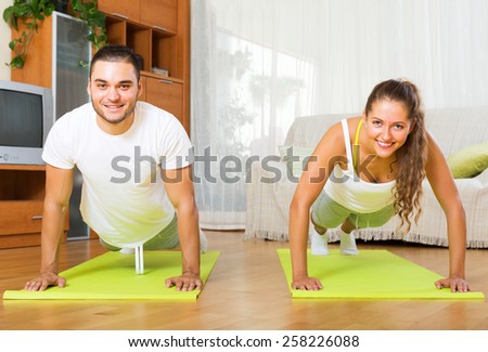 Smiling people doing yoga on mats in interior