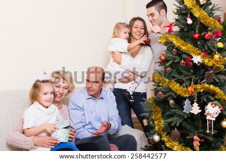 Adults and kids helping grand parent to set Xmas tree