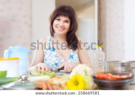 woman cutting the celery for salad in home kitchen