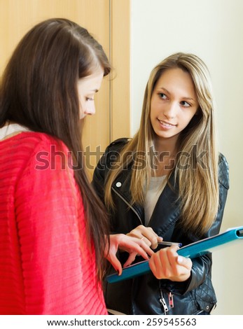 woman answers the questions in door at home. Focus on blonde