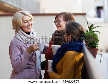 Portrait of happy female pensioners drinking coffee at patio